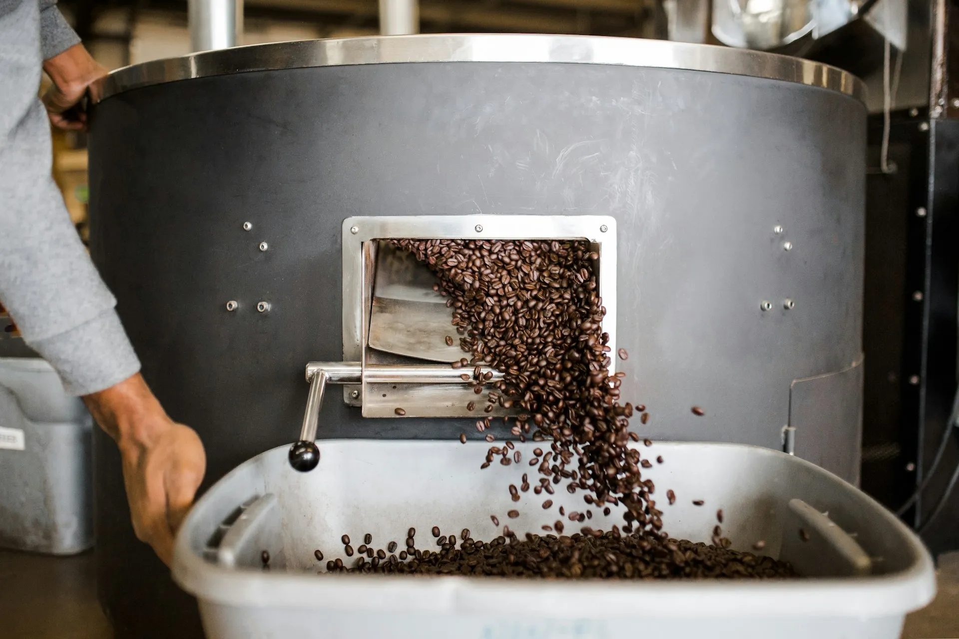 Person holding stainless steel tray with brown and black beads